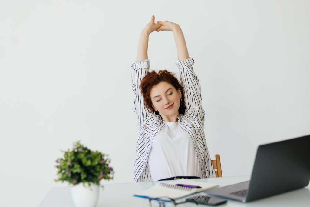 Employé au bureau qui s'étire et prend une pause